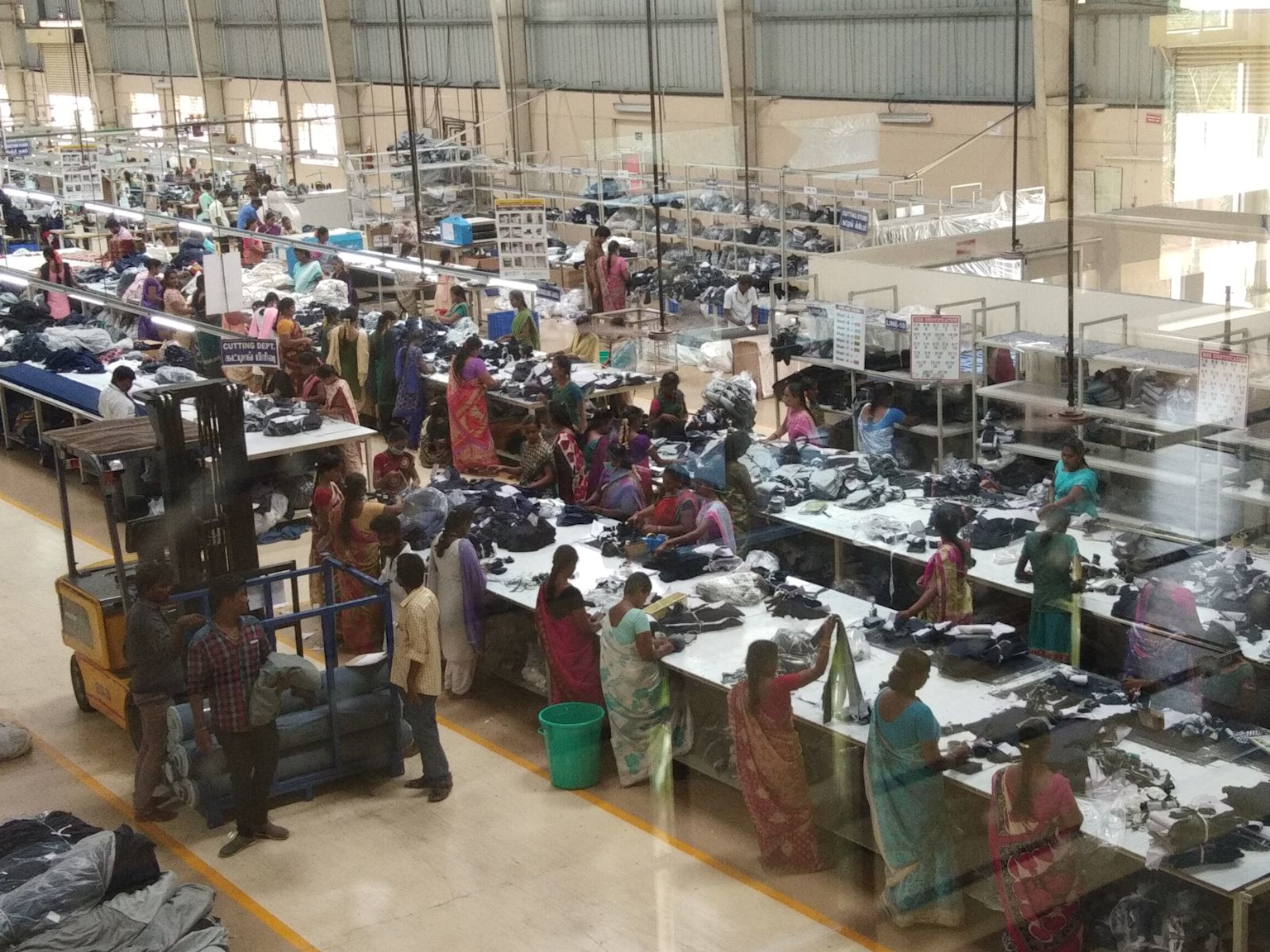 Indian garment factory workers sorting and handling clothes in manufacturing setting